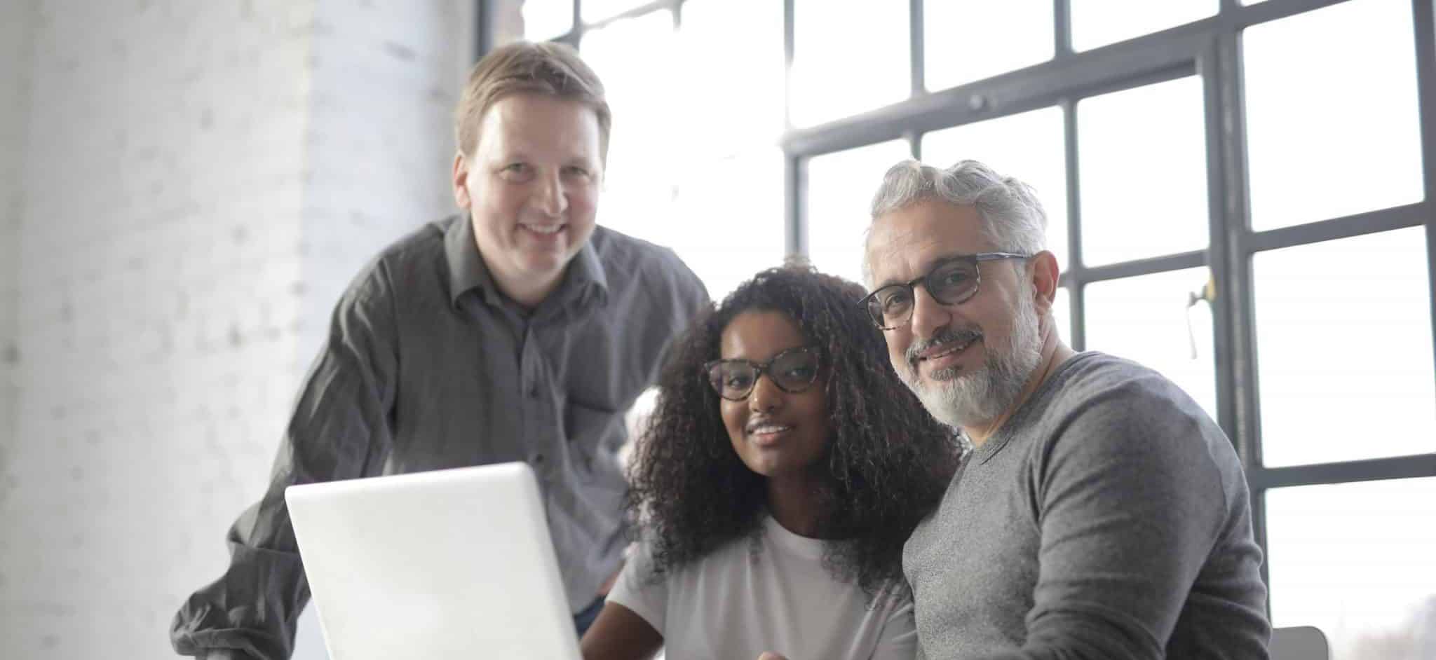 a group of people looking at a laptop